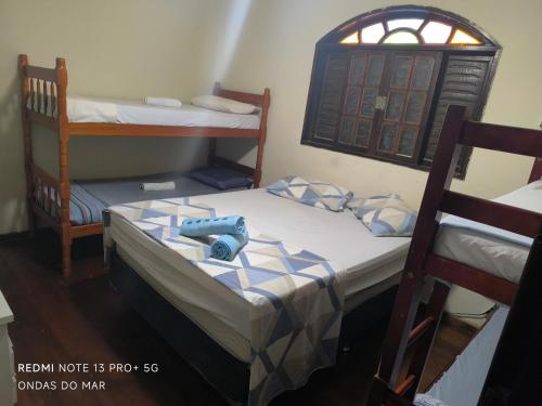 two bunk beds in a room with a window at Pousada Ondas do Mar Cabo Frio in Cabo Frio