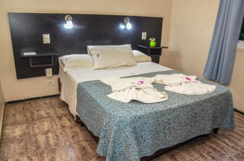 a hotel room with a bed with two towels on it at Castelar in Mendoza