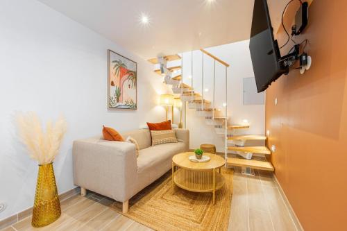 un salon avec un canapé et un escalier en colimaçon dans l'établissement L'écrin de la Seine, à Andrésy