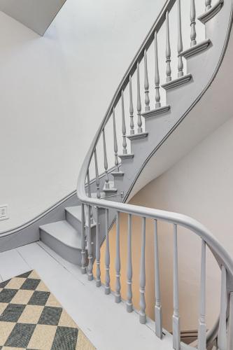 a stairway with a checkerboard floor and a stair case at Explore Dtwn, Parks and Colleges Cozy Worcester Apt in Worcester