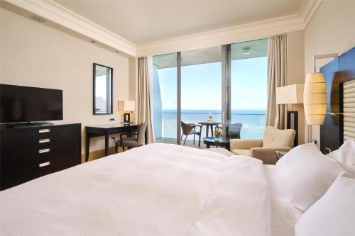 a hotel room with a bed and a view of the ocean at Kempinski Hotel Adriatic Istria Croatia in Savudrija
