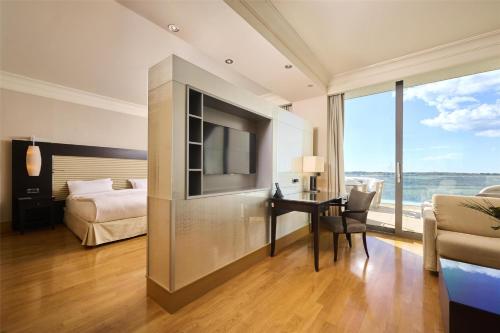 a hotel room with a bed and a desk with a television at Kempinski Hotel Adriatic Istria Croatia in Savudrija