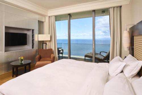 a bedroom with a bed and a view of the ocean at Kempinski Hotel Adriatic Istria Croatia in Savudrija