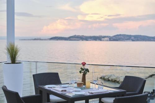 a table with wine glasses and a flower on it at Kempinski Hotel Adriatic Istria Croatia in Savudrija