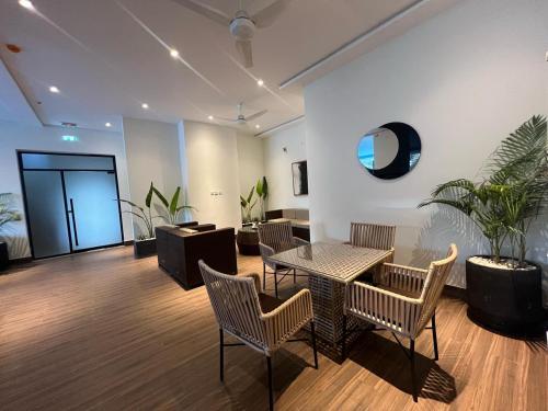 a room with a table and chairs and a potted plant at Aurum Luxury Apartments Gulberg Lahore - LMY in Lahore