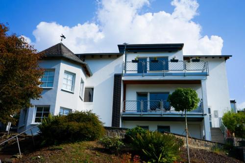 a white house with a balcony on a hill at Landliebe Nummer 10 in Braubach