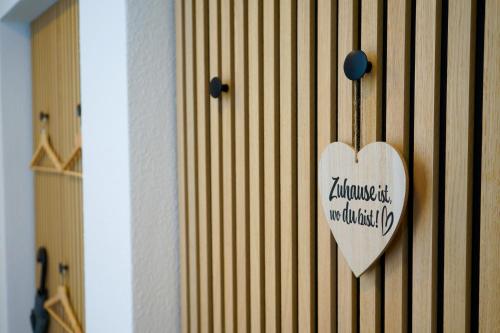 a wooden heart hanging on a wall with a sign at Landliebe Nummer 10 in Braubach
