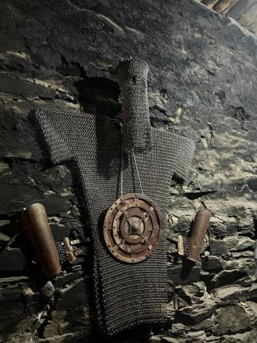 a metal cross on the side of a stone wall at Hotel Front Castle in Shatili