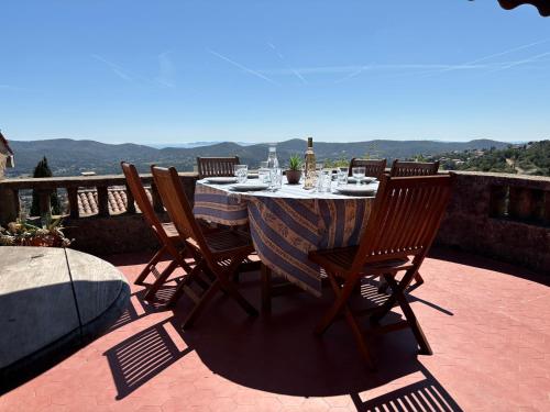 - une table avec des chaises assises sur une terrasse dans l'établissement Magnifique maison de village clim vue mer 6 pers, à Bormes-les-Mimosas