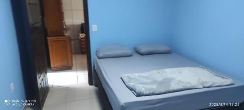 a blue bed with two pillows on it in a room at casa do tidi in Rondônia