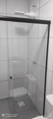a shower with a glass door in a bathroom at casa do tidi in Rondônia