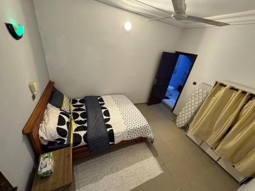 Un dormitorio con una cama con un edredón blanco y negro. en Cozy Apartment near the GMK stadium, en Cotonou