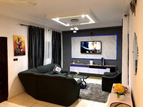 una sala de estar con un sofá y una mesa en Cozy Apartment near the GMK stadium, en Cotonou