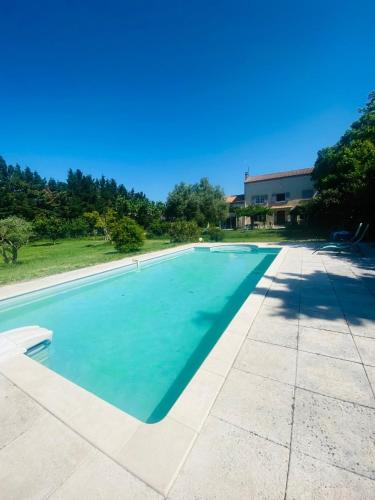 une grande piscine avec de l'eau bleue dans l'établissement Mas en Provence, à Graveson