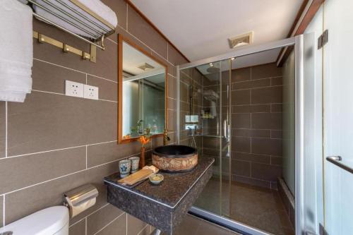a bathroom with a shower and a sink and a toilet at Castle peak yard Inn Free railway st ation pick-up by 2 nights English and Spanish reception available in Guilin