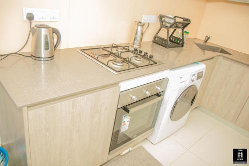 a kitchen with a stove and a washing machine at Luxury fairway living-Galle apartments in Galle