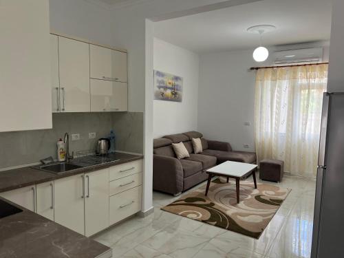 a kitchen and a living room with a couch at Horizont City-Center in Shkodër