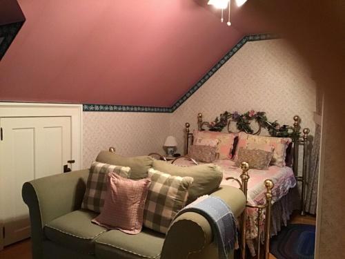 a bedroom with a bed and a couch and a chair at Brookview Manor Inn in Canadensis