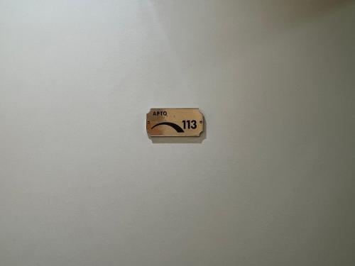 a clock on a white wall with an arrow at Flat Santana próximo ao metrô Apto 113 in Sao Paulo
