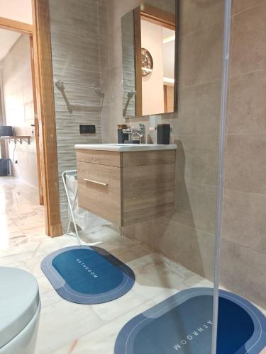 a bathroom with a sink and a toilet and a mirror at Appart Moderne Vue mer latérale & piscine - Plage des Sablettes El Mansouria in Ben Slimane