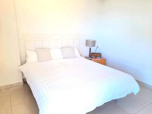 a bedroom with a white bed and a lamp on a table at BEACH VALENCIA LUXURY D15-21 Apartment with terrace and sea views with two rooms in Valencia