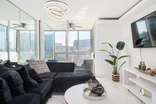 a living room with a black couch and some windows at 2B Downtown ATL Condo Free Parking 24h Concierge LM707 in Atlanta