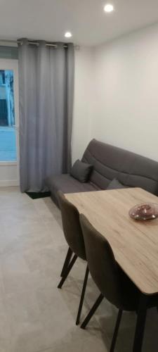 a living room with a table and a couch at Appartement cosy à Le Caylar 38m² avec parking in Le Caylar