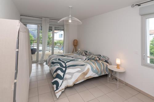 a bedroom with a bed and a table and a window at Appartement BRISE MARINE in Labenne