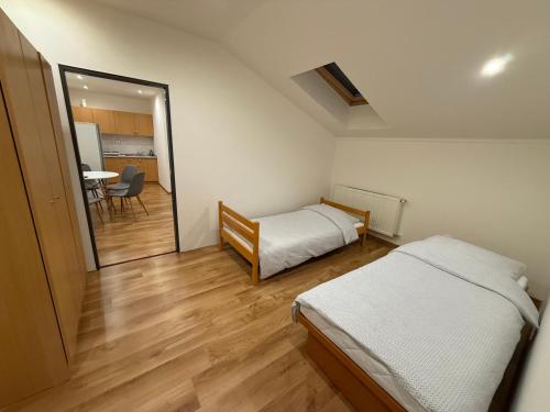 a bedroom with two beds and a dining room with a table at Ubytovanie Stavbar in Štúrovo