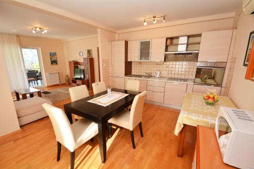 a kitchen and dining room with a black table and chairs at Apartments Soso in Kotor