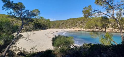 a beach with people on the sand and water at Hostal Can Jordi in Cala Figuera