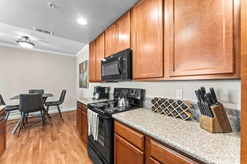 a kitchen with wooden cabinets and a black stove top oven at New Cozy 1BR Apt with Gym Sauna & Heated Pool Access in Reno