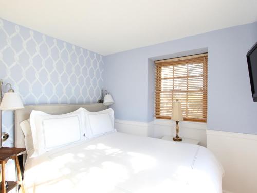 a bedroom with a white bed and a window at Charles and Charles MV in Vineyard Haven
