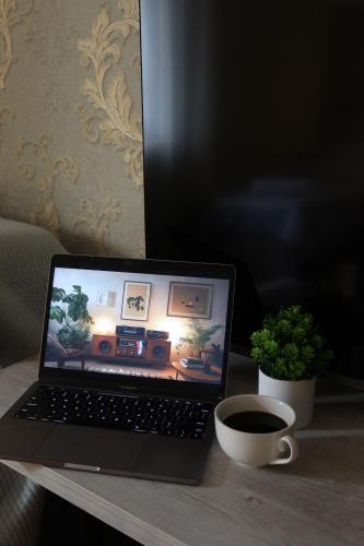 a laptop computer sitting on a table with a cup of coffee at Lavitor hotel in Bishkek