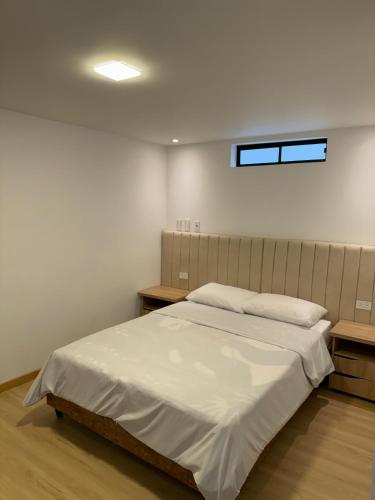a bedroom with a large white bed with two tables at Hotel 168 Pasto in Pasto