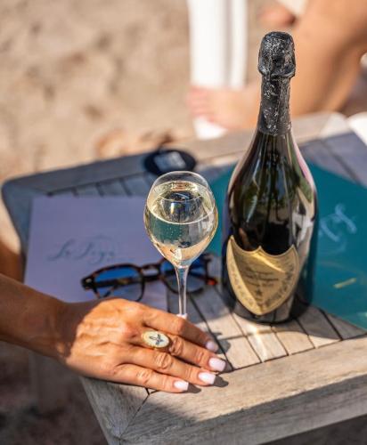 une femme tenant un verre de vin à côté d'une bouteille dans l'établissement Le Soleil d’or, à Théoule-sur-Mer