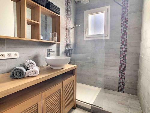 une salle de bain avec un lavabo et une douche dans l'établissement La maison de Yali, à Auray