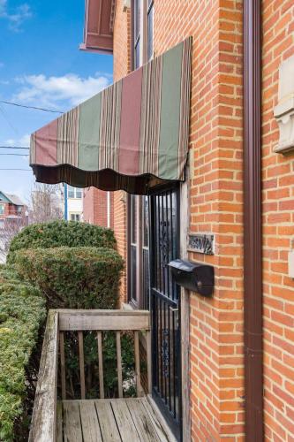 awning over the door of a building with a wooden porch at Short north- STEPS to High St -Private Parking-OSU in Milo