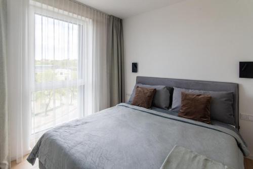 Un dormitorio con una cama con una ventana grande. en Algirdo central stay, en Vilna