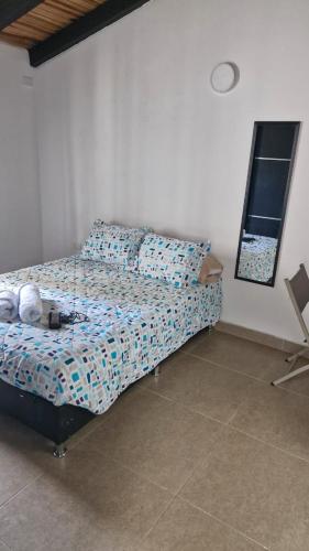 a bedroom with a bed and a mirror and a window at Mini Aptoestudio para 2 personas in Cúcuta