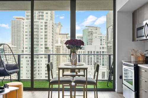 a kitchen with a table with a vase of flowers on it at Penthouse Infinity heated pool and jacuzzi in Miami