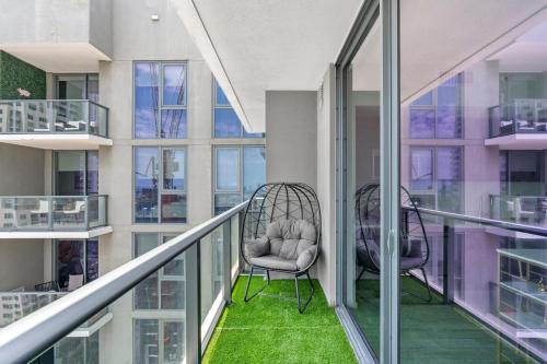 a balcony with two chairs and green carpet at Penthouse Infinity heated pool and jacuzzi in Miami