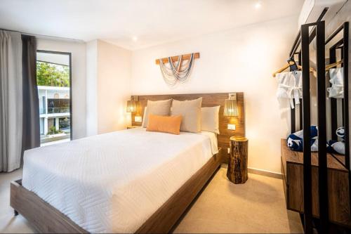 a bedroom with a large white bed and a window at Lia Hotel Jaco in Jacó