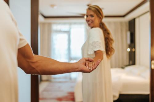 a bride and groom holding hands in a hotel room at Bucuti & Tara Boutique Beach Resort - Adult Only in Palm-Eagle Beach
