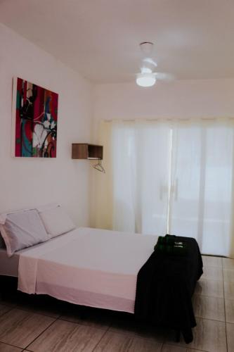 a bedroom with a white bed and a window at Autonomia em Niterói com praticidade e conforto in Niterói