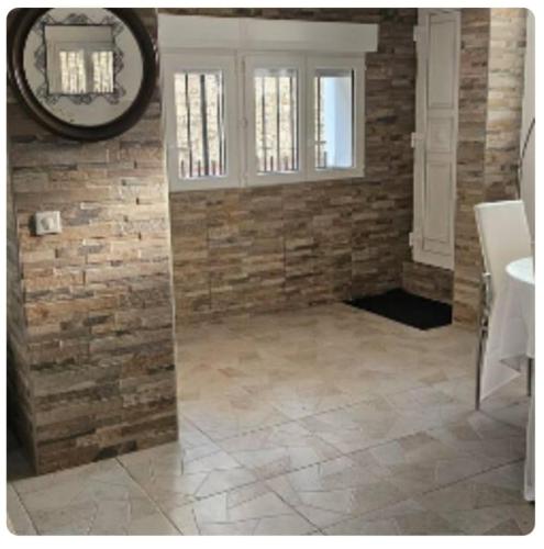 La salle de bains est pourvue d'un mur en briques et d'un miroir. dans l'établissement Luxurious Apartment Cannes city center five minutes from beach, à Cannes