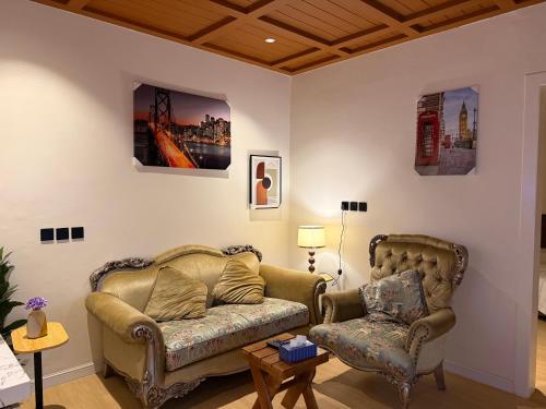 a living room with a couch and a chair at بيتي بلس للغرف الفندقية- مدخل مستقل in Riyadh Al Khabra