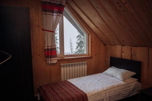 a bedroom with a bed in a room with a window at Міні-готель Файна файта in Dragobrat