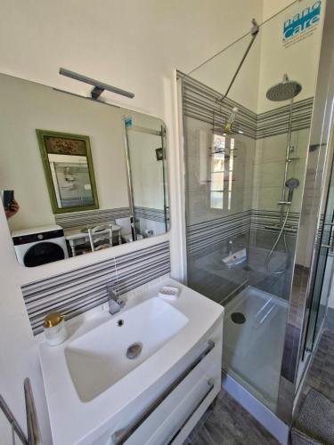 une salle de bain avec un lavabo blanc et une douche dans l'établissement Maison la Bourbonnaise, proche des Thermes, à Bourbon-lʼArchambault