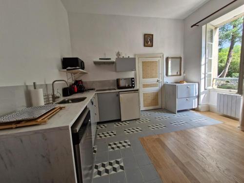 a kitchen with white appliances and a large window at Les Demeures du Parc, la Bourbonnaise, proche des Thermes in Bourbon-lʼArchambault